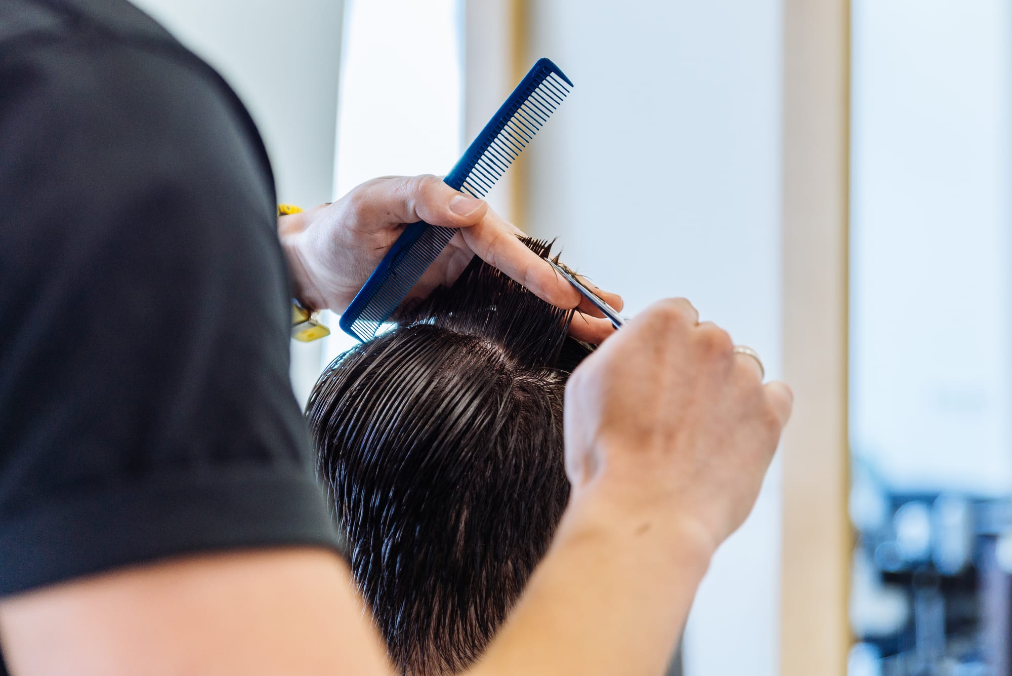 Kapper knipt haar met kam en schaar