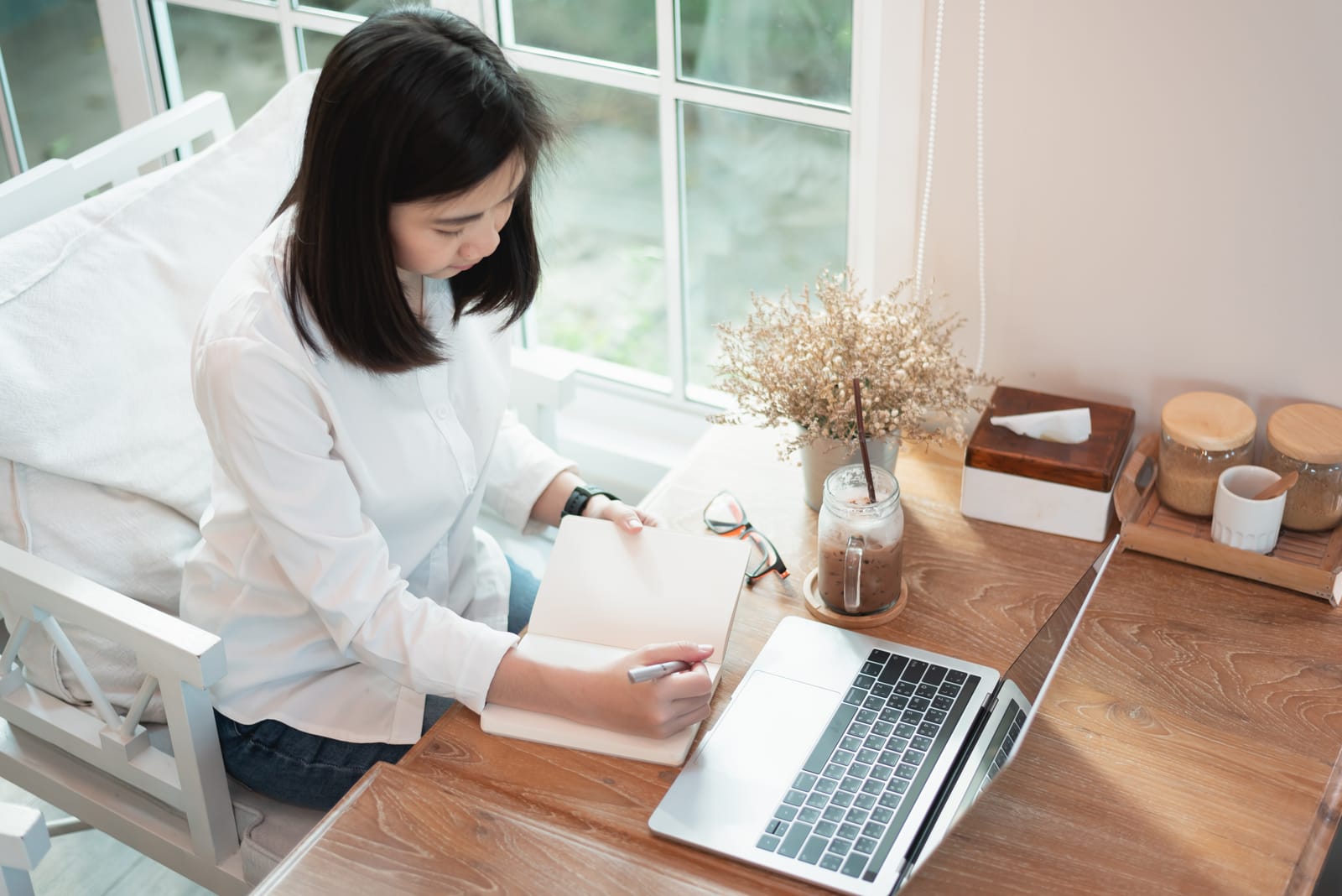 Vrouw werkt aan een tekst op haar laptop aan een licht bureau