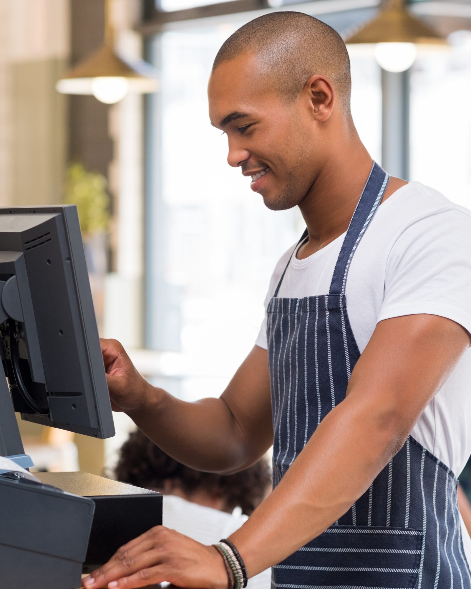 Medewerker in een café tikt een bestelling in op de kassa